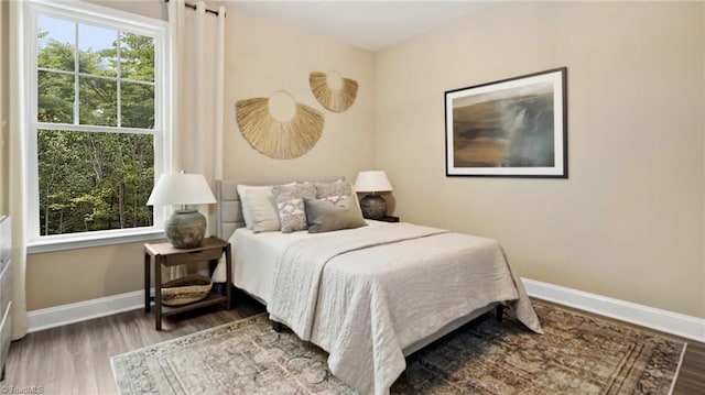 bedroom featuring wood-type flooring and multiple windows