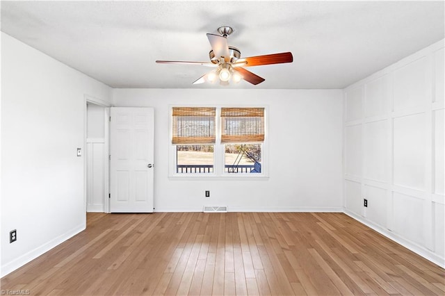 empty room featuring baseboards, light wood-type flooring, visible vents, and a ceiling fan