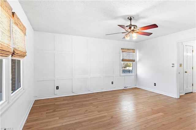 unfurnished room featuring light hardwood / wood-style floors, ceiling fan, and a textured ceiling