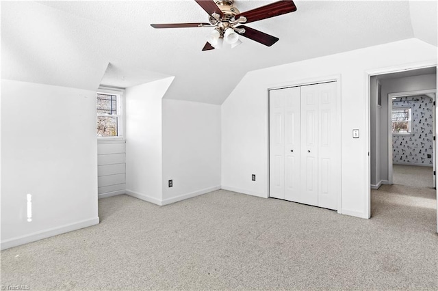 bonus room featuring lofted ceiling, plenty of natural light, and carpet flooring