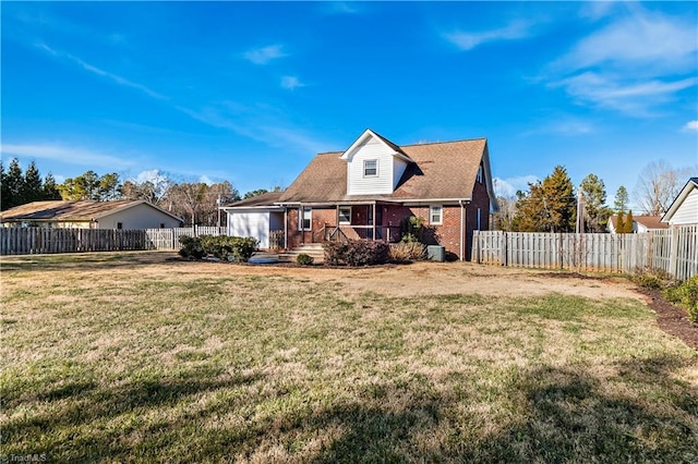 back of house with a yard, a fenced backyard, and brick siding