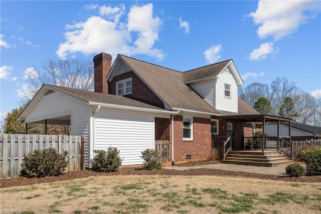 view of home's exterior with a shingled roof, a chimney, crawl space, fence, and brick siding