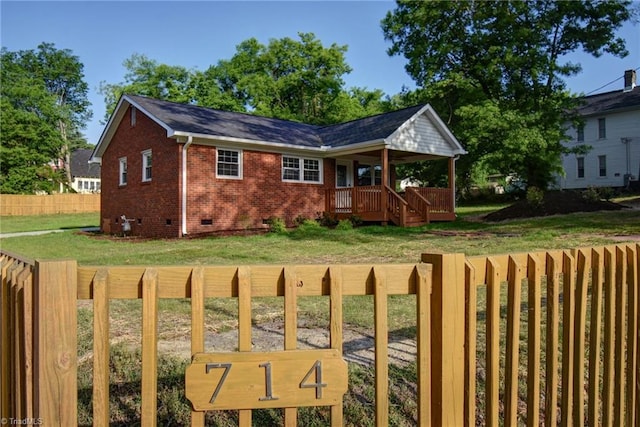 714 Martin St, Greensboro, NC 27406 - view of front facade with fence, a front lawn, brick siding, a porch, and crawl space