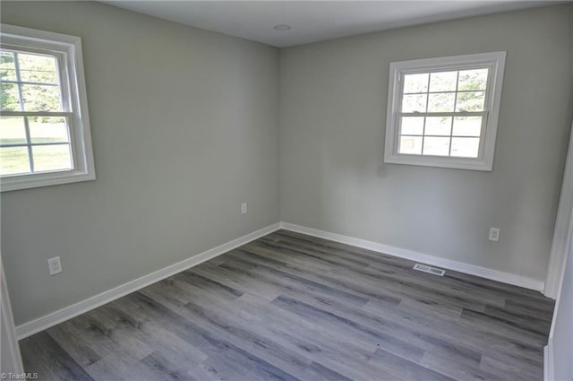714 Martin St, Greensboro, NC 27406 - empty room with baseboards, visible vents, a wealth of natural light, and dark wood finished floors