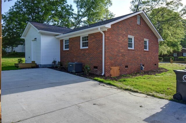 714 Martin St, Greensboro, NC 27406 - view of side of home with a lawn, central AC unit, brick siding, and crawl space