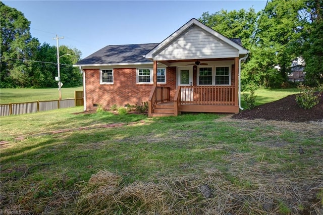714 Martin St, Greensboro, NC 27406 - view of front facade featuring ceiling fan, fence, a front yard, brick siding, and crawl space