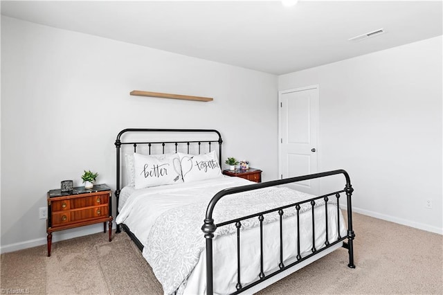 carpeted bedroom featuring baseboards and visible vents