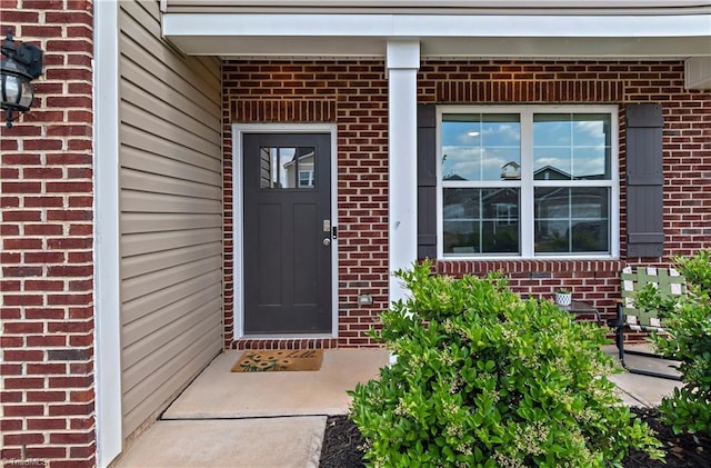 entrance to property featuring brick siding