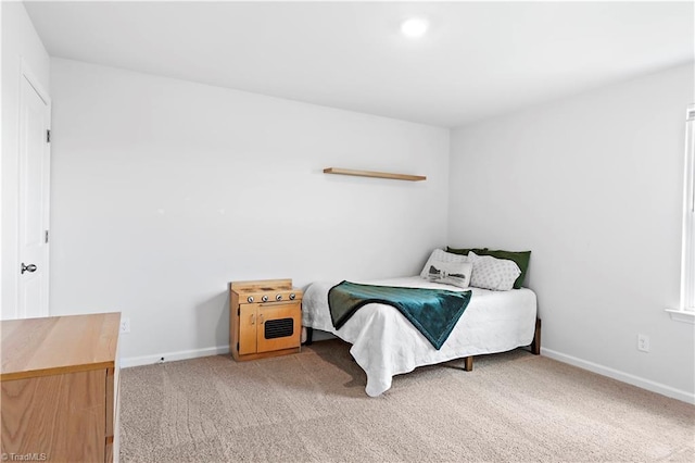 bedroom with baseboards and light carpet