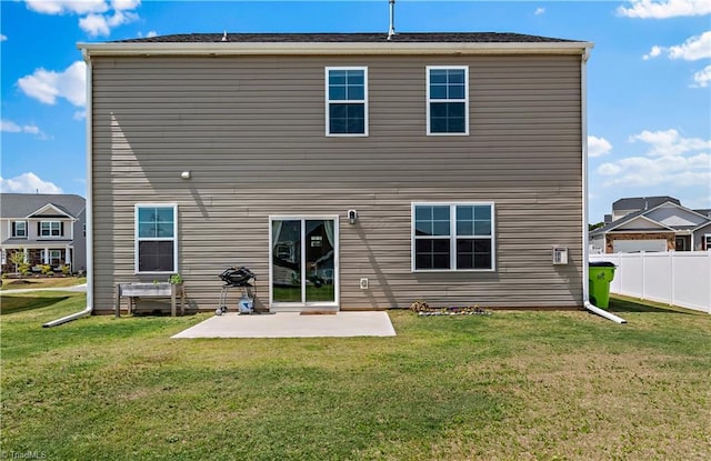 rear view of house with a lawn, a patio, and fence