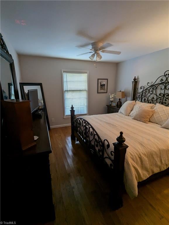 bedroom with ceiling fan and dark wood-type flooring