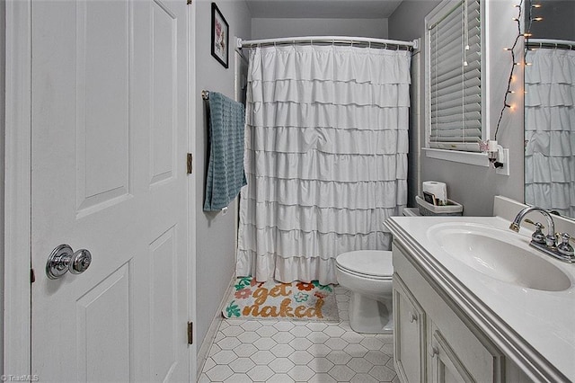 bathroom featuring tile patterned floors, curtained shower, vanity, and toilet