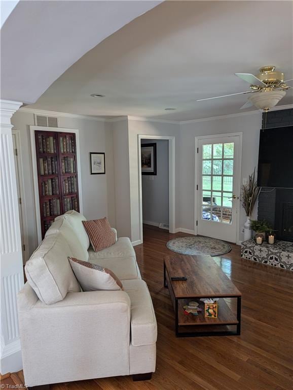 living room featuring crown molding, dark wood-type flooring, and ceiling fan