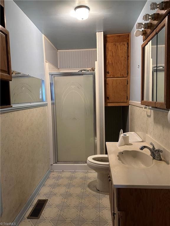 bathroom featuring vanity, toilet, and walk in shower