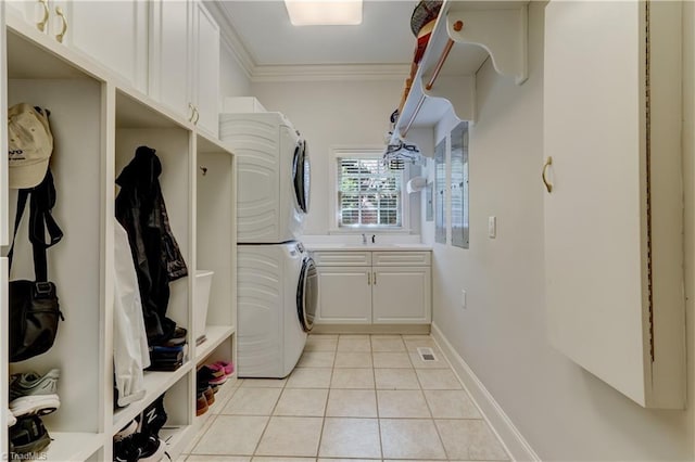 10 Sunfish Pt, Greensboro, NC 27455 - washroom with stacked washer / dryer, cabinet space, crown molding, light tile patterned flooring, and baseboards