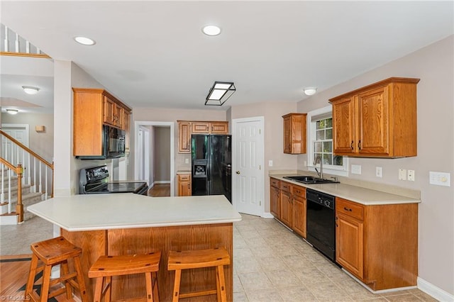 4335 Clovelly Dr, Greensboro, NC 27406 - kitchen featuring black appliances, a peninsula, light countertops, a kitchen breakfast bar, and recessed lighting