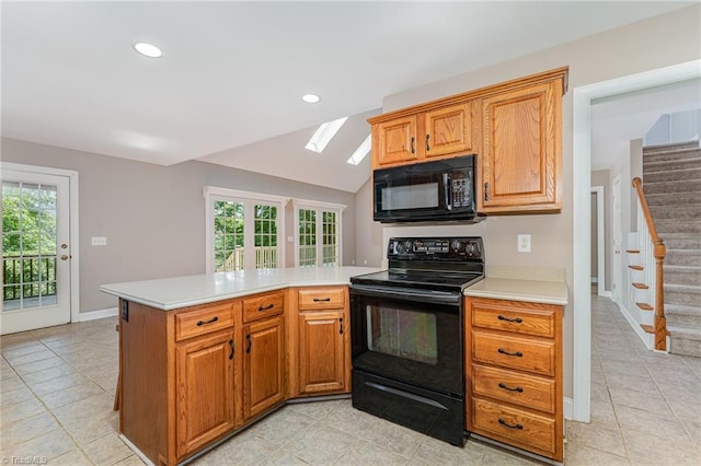 4335 Clovelly Dr, Greensboro, NC 27406 - kitchen featuring black appliances, a skylight, light countertops, a peninsula, and light tile patterned floors