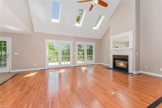 4335 Clovelly Dr, Greensboro, NC 27406 - unfurnished living room featuring high vaulted ceiling, a ceiling fan, light wood-style floors, a fireplace with flush hearth, and plenty of natural light