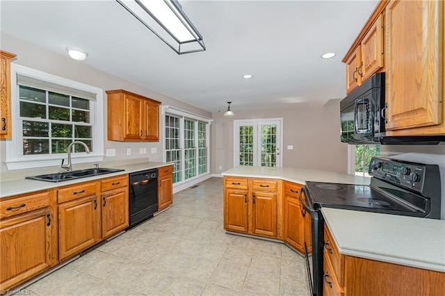 4335 Clovelly Dr, Greensboro, NC 27406 - kitchen with black appliances, a peninsula, light countertops, brown cabinetry, and recessed lighting