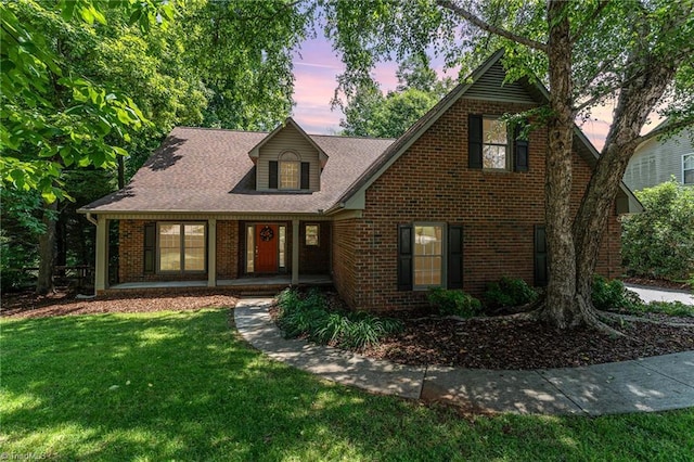 4335 Clovelly Dr, Greensboro, NC 27406 - traditional-style house with a front lawn, brick siding, a porch, and a shingled roof