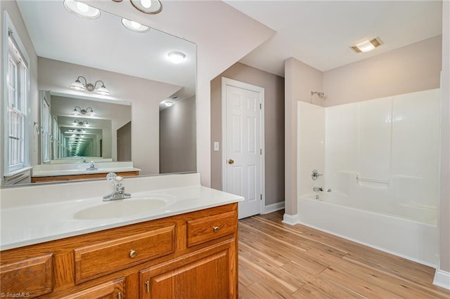 4335 Clovelly Dr, Greensboro, NC 27406 - full bathroom with washtub / shower combination, vanity, and wood finished floors