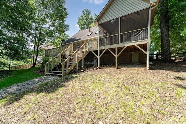 4335 Clovelly Dr, Greensboro, NC 27406 - back of property featuring stairs, a sunroom, and a wooden deck