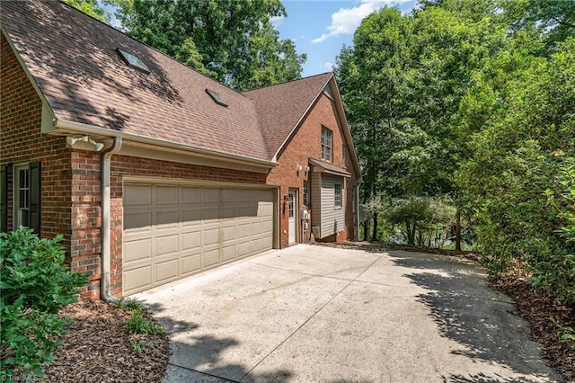 4335 Clovelly Dr, Greensboro, NC 27406 - view of property exterior with roof with shingles, brick siding, concrete driveway, and a garage