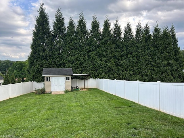 view of yard with a fenced backyard, a storage unit, and an outdoor structure