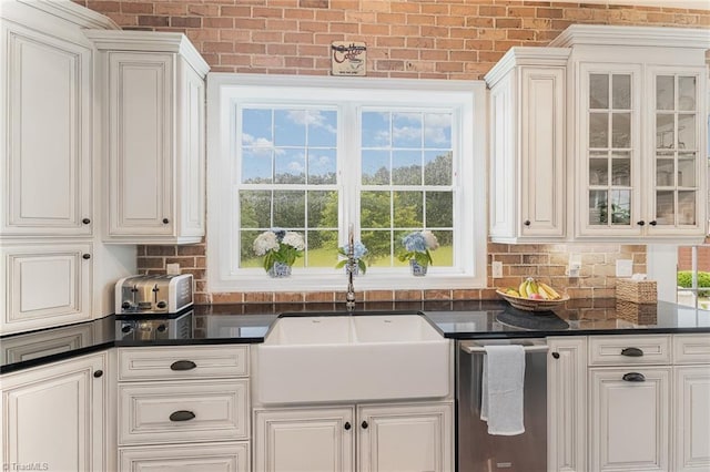 2733 Nebo Rd, East Bend, NC 27018 - kitchen with dark countertops, white cabinetry, glass insert cabinets, and brick wall