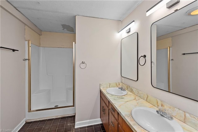 bathroom featuring tile patterned floors, a shower with door, and vanity