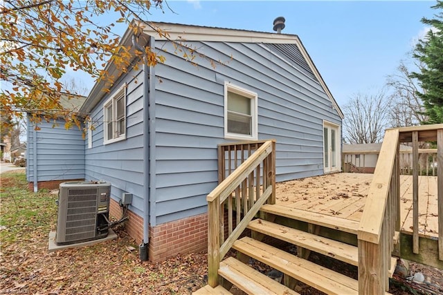 exterior space with central AC unit and a wooden deck