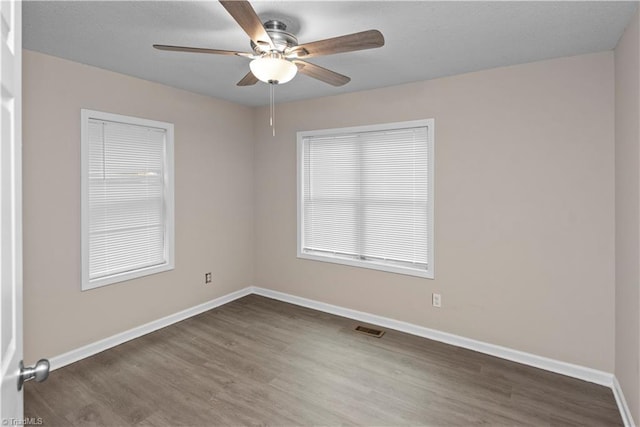 spare room featuring dark hardwood / wood-style floors and ceiling fan