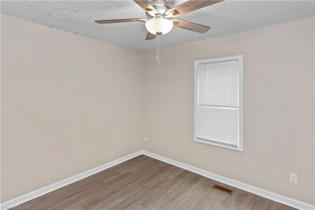 empty room with hardwood / wood-style flooring, ceiling fan, and a textured ceiling