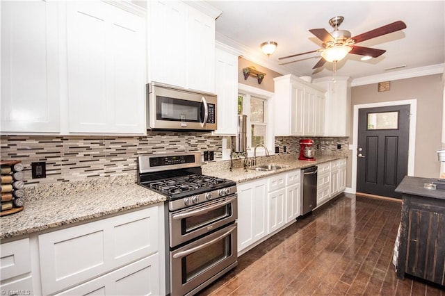 kitchen featuring appliances with stainless steel finishes, crown molding, decorative backsplash, and white cabinets