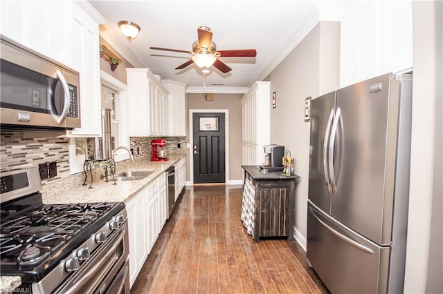 kitchen featuring backsplash, sink, appliances with stainless steel finishes, hardwood / wood-style flooring, and crown molding