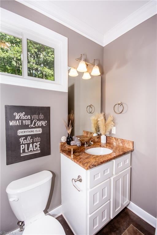 bathroom featuring toilet, crown molding, vanity, and tile patterned floors