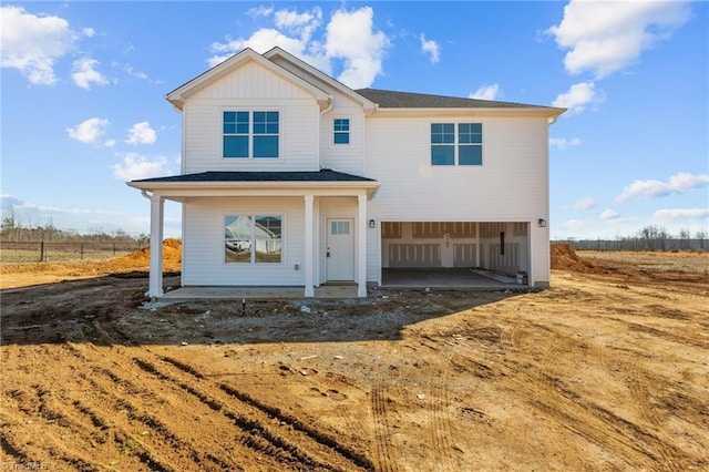 view of front of home featuring a garage, a porch, and a rural view