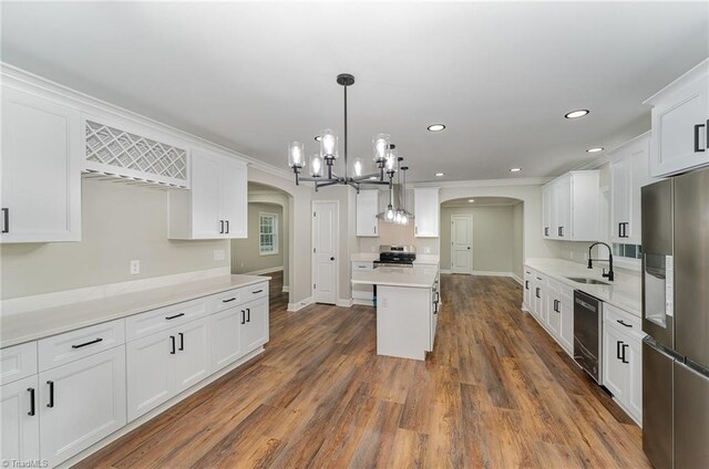 kitchen featuring sink, hanging light fixtures, dark hardwood / wood-style floors, white cabinets, and appliances with stainless steel finishes