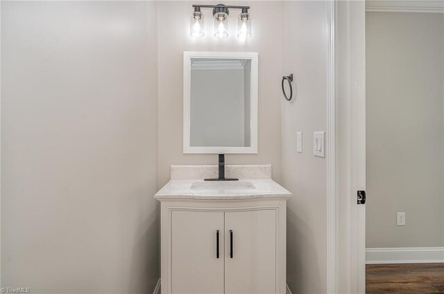 bathroom with hardwood / wood-style floors, vanity, and crown molding