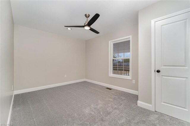 carpeted spare room with ceiling fan