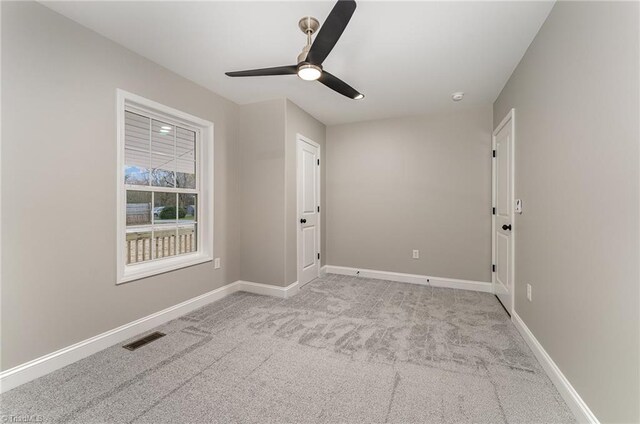 unfurnished room featuring light carpet and ceiling fan