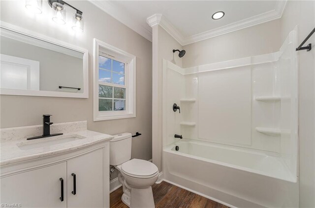 full bathroom featuring hardwood / wood-style floors, vanity,  shower combination, crown molding, and toilet