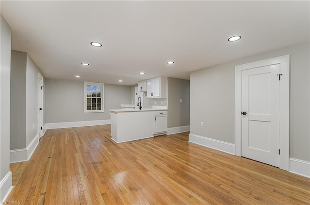 interior space featuring white cabinetry, kitchen peninsula, and light hardwood / wood-style flooring