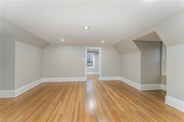 bonus room with light hardwood / wood-style flooring and vaulted ceiling