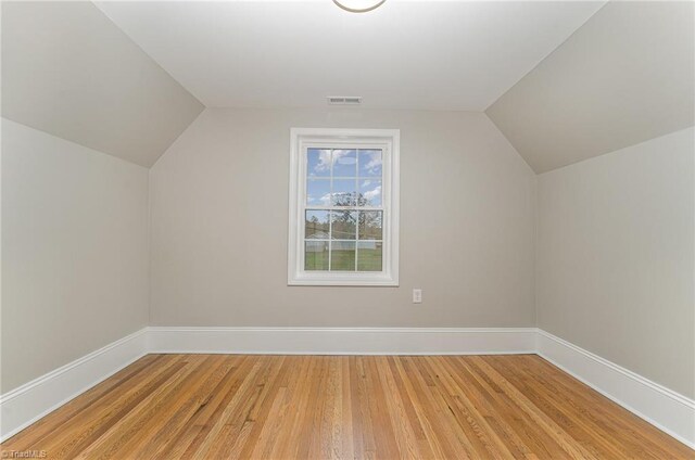 bonus room with hardwood / wood-style floors and vaulted ceiling