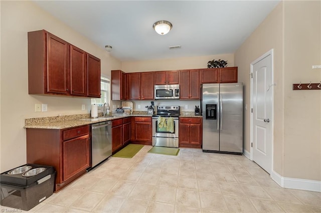 1720 Timber Cove Ct, Winston-Salem, NC 27127 - kitchen featuring visible vents, dark brown cabinets, baseboards, light stone counters, and appliances with stainless steel finishes