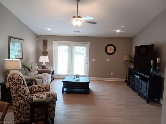 living room with ceiling fan, lofted ceiling, and light hardwood / wood-style flooring