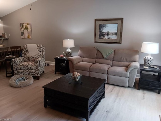 living room featuring vaulted ceiling and light hardwood / wood-style flooring