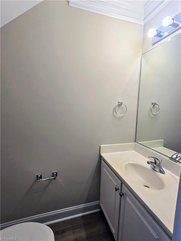 bathroom with hardwood / wood-style floors, vanity, toilet, and crown molding