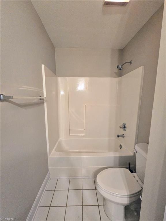 bathroom featuring toilet, tile patterned floors, and  shower combination